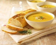 Squash Soup with Sage and Pumpkin Seeds; Sliced Loaf of Bread